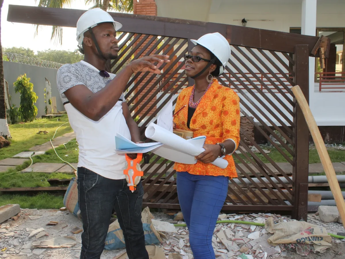 Architecte, casque de chantier et plans en main, en réunion sur site