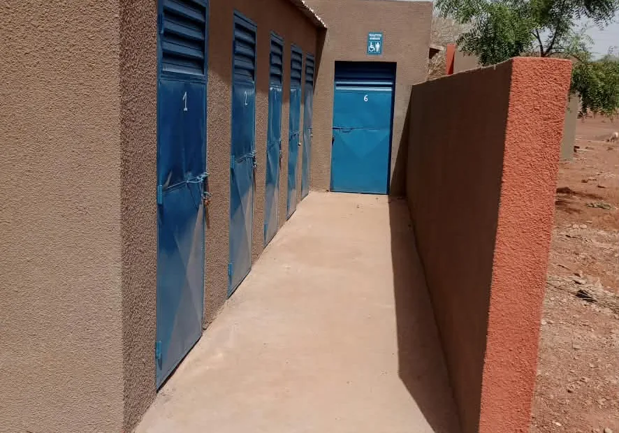 Bloc de latrines publiques aux portes bleues, construit par Arkyda