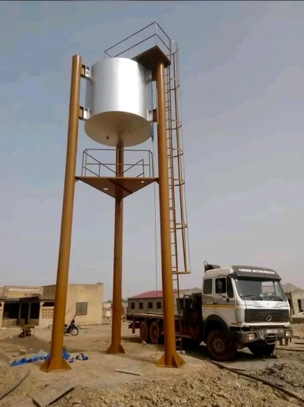 Château d’eau en cours de montage, camion de forage au pied